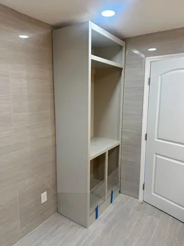 a view of an empty room with wooden floor and a hallway