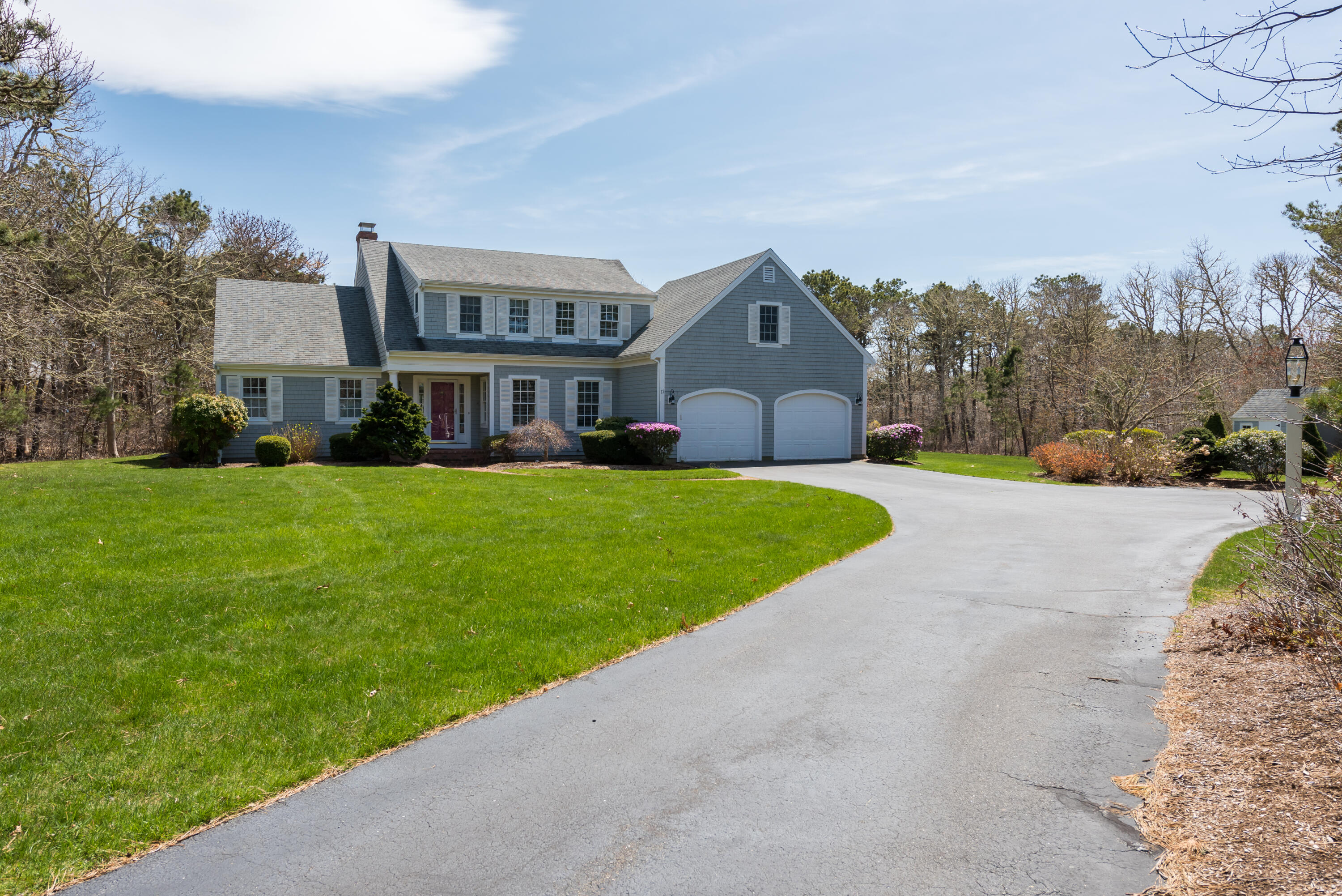 a view of a house with a yard and large trees