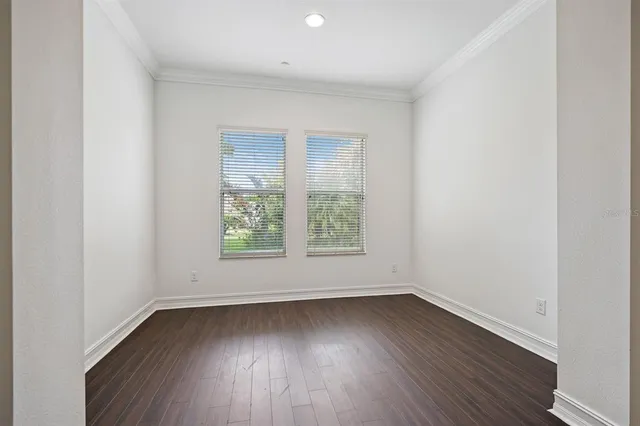 an empty room with wooden floor and window