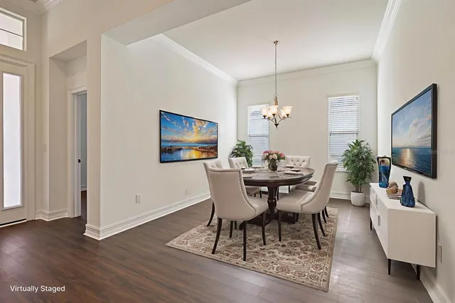a dining room with furniture potted plants and wooden floor