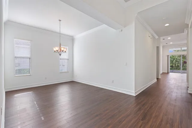a view of empty room with wooden floor and window