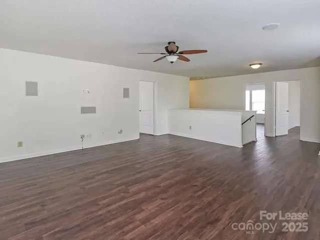 a view of a big room with wooden floor and windows in a room