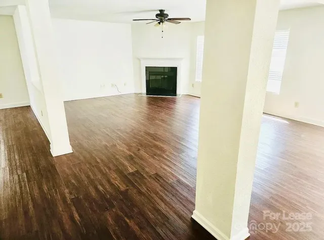 a view of a hallway with wooden floor and a fireplace