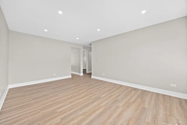 a view of an empty room with wooden floor
