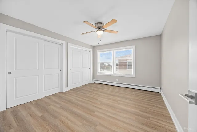 a view of an empty room with a window and a ceiling fan