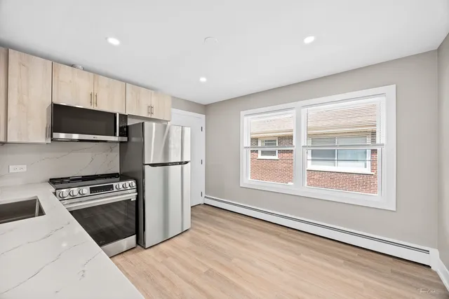 a kitchen with stainless steel appliances a refrigerator stove and microwave