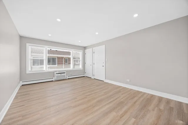 a view of empty room with wooden floor and windows