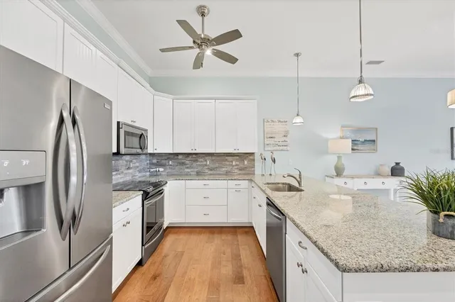 a kitchen with granite countertop a sink a counter top space and living room view