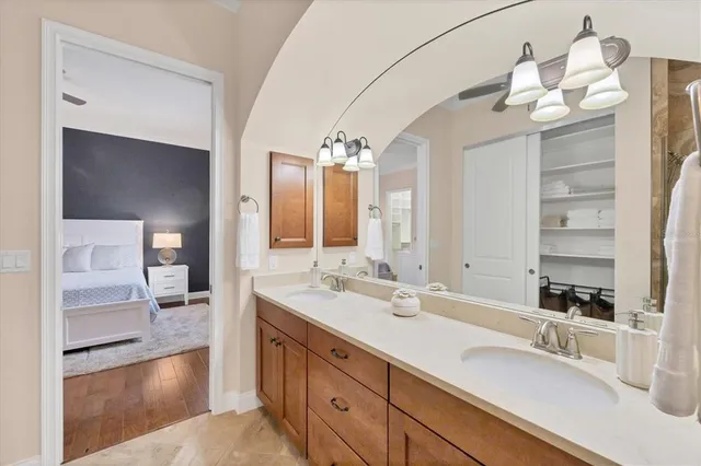 a bedroom with a bed and a lamp on dresser next to a window