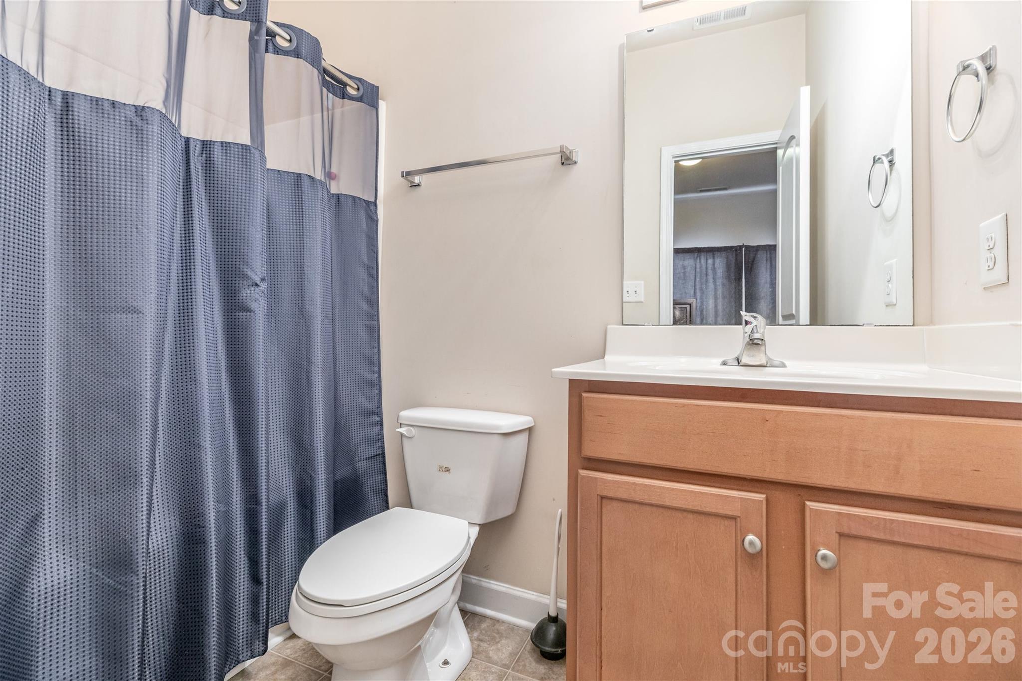 7167 April Mist Trail Huntersville, NC 28078 - Photo 14 of 19 a bathroom with a toilet a sink and a mirror