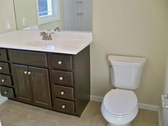 a bathroom with a toilet a sink and mirror