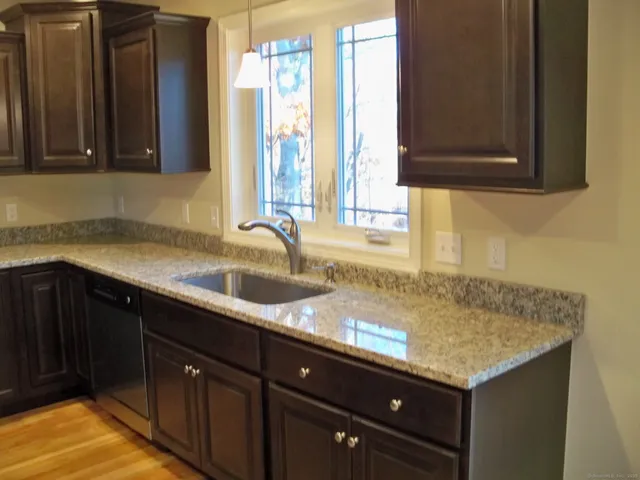 a kitchen with granite countertop a sink and a wooden cabinets