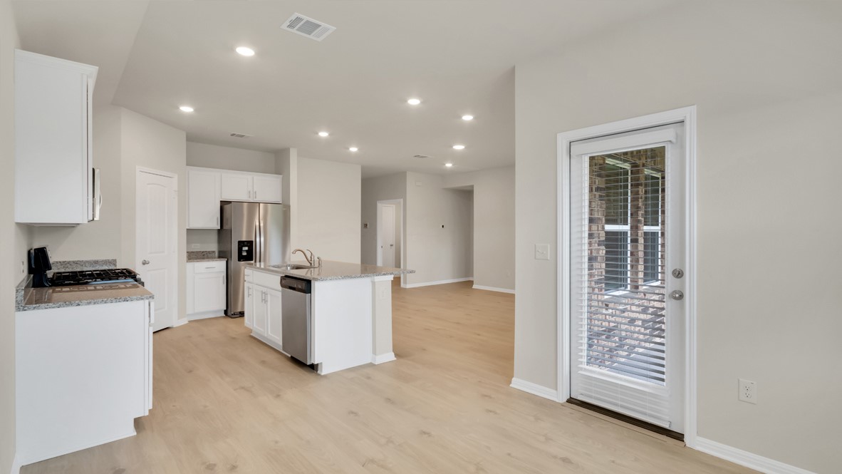 1817 Side Buster Trail Leander, TX 78641 - Photo 20 of 25 a kitchen with white cabinets and white appliances