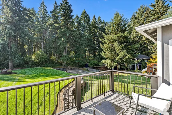 a view of a roof deck with wooden fence and trees