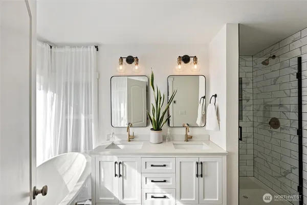 a bathroom with double vanity sink and a mirror