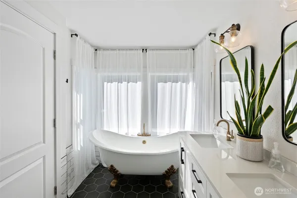 a bathroom with a sink a mirror and a potted plant