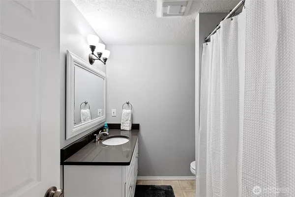 a bathroom with a granite countertop sink and a mirror