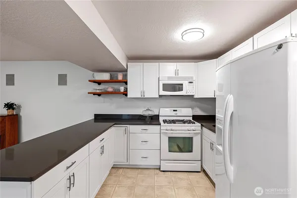 a kitchen with white cabinets and white appliances