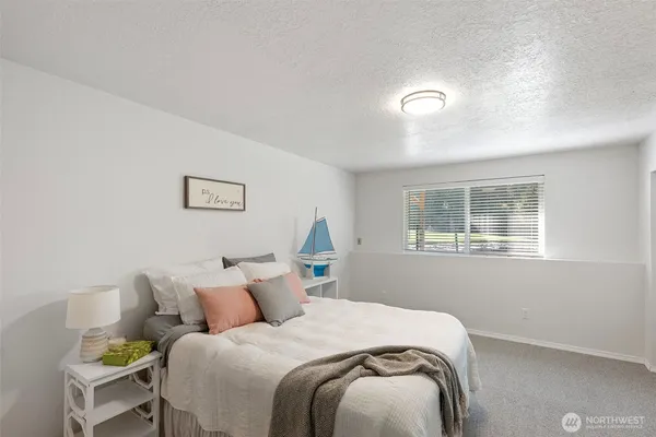 a bed sitting in a bedroom next to a window