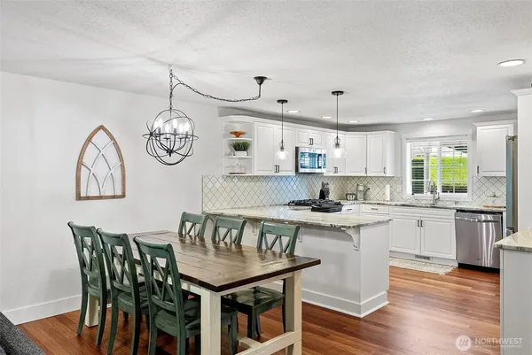 a kitchen with a table chairs and wooden floor