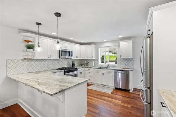 a kitchen with stainless steel appliances granite countertop a sink stove and refrigerator