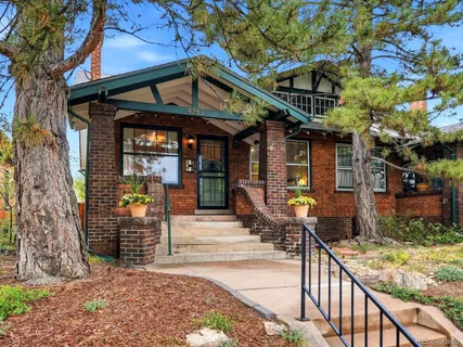 a front view of a house with a tree