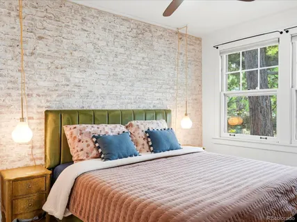 a bed room with a bed a television and a window