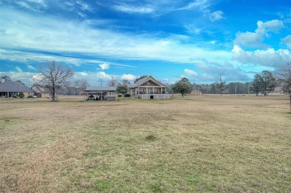 a view of a field with an trees in the background