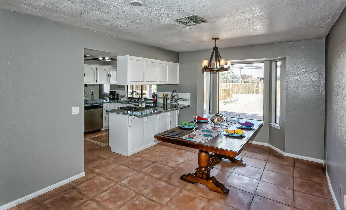 20140 Sahale Road Apple Valley, CA 92307 - Photo 20 of 45 a kitchen with a stove a chimney a dining table and chairs