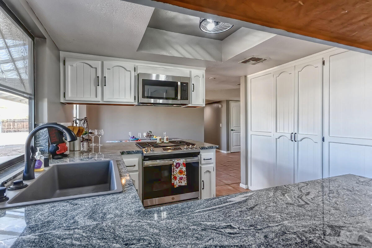 20140 Sahale Road Apple Valley, CA 92307 - Photo 24 of 45 a kitchen with stainless steel appliances granite countertop a stove a sink and a microwave