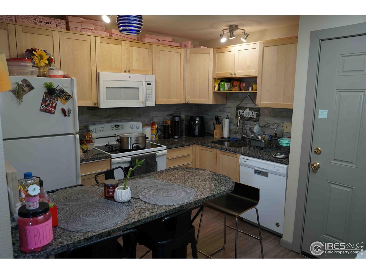 903 18th Street, Unit 302 Boulder, CO 80302 - Photo 6 of 10 a kitchen with kitchen island granite countertop a sink cabinets and stainless steel appliances
