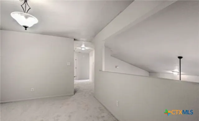 a view of an empty room and chandelier fan