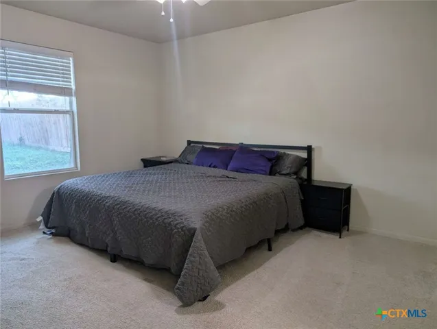 a bed sitting in a bedroom next to a window