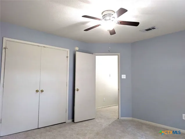 a view of a chandelier fan and closet in a room