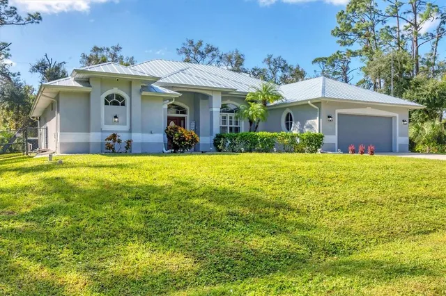 a view of a house with a big yard and large trees