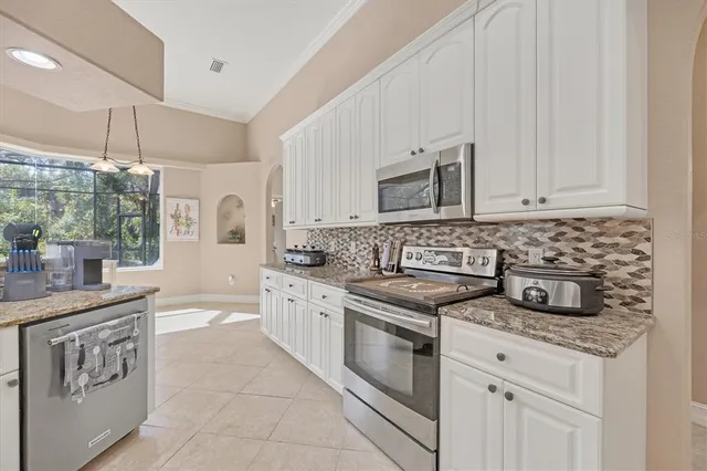 a kitchen with granite countertop a sink stove and cabinets
