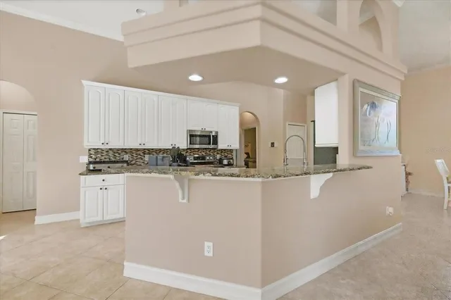 a kitchen with stainless steel appliances a refrigerator and white cabinets