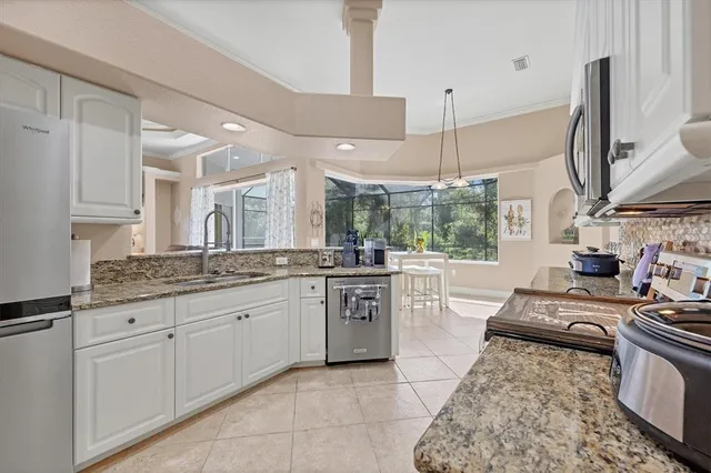 a large kitchen with kitchen island granite countertop a stove a sink a dining table and chairs