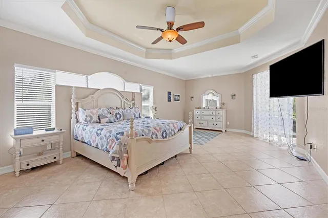 a bedroom with a bed and a flat tv screen on the dresser
