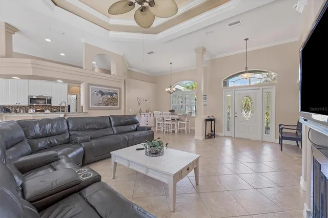 a living room with furniture a chandelier and a flat screen tv