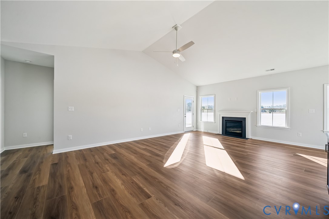 115 Logan Way Tappahannock, VA 22560 - Photo 11 of 29 an empty room with wooden floor fireplace and windows