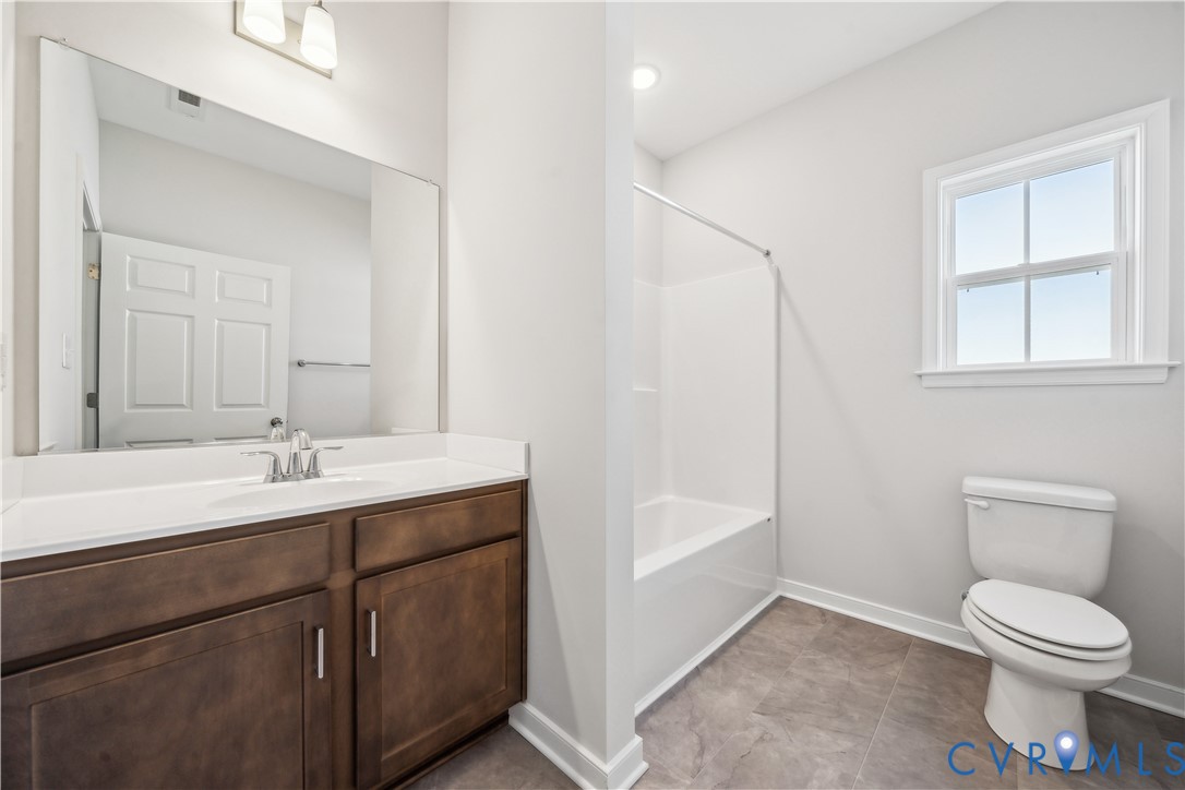 115 Logan Way Tappahannock, VA 22560 - Photo 14 of 29 a bathroom with a toilet sink and mirror