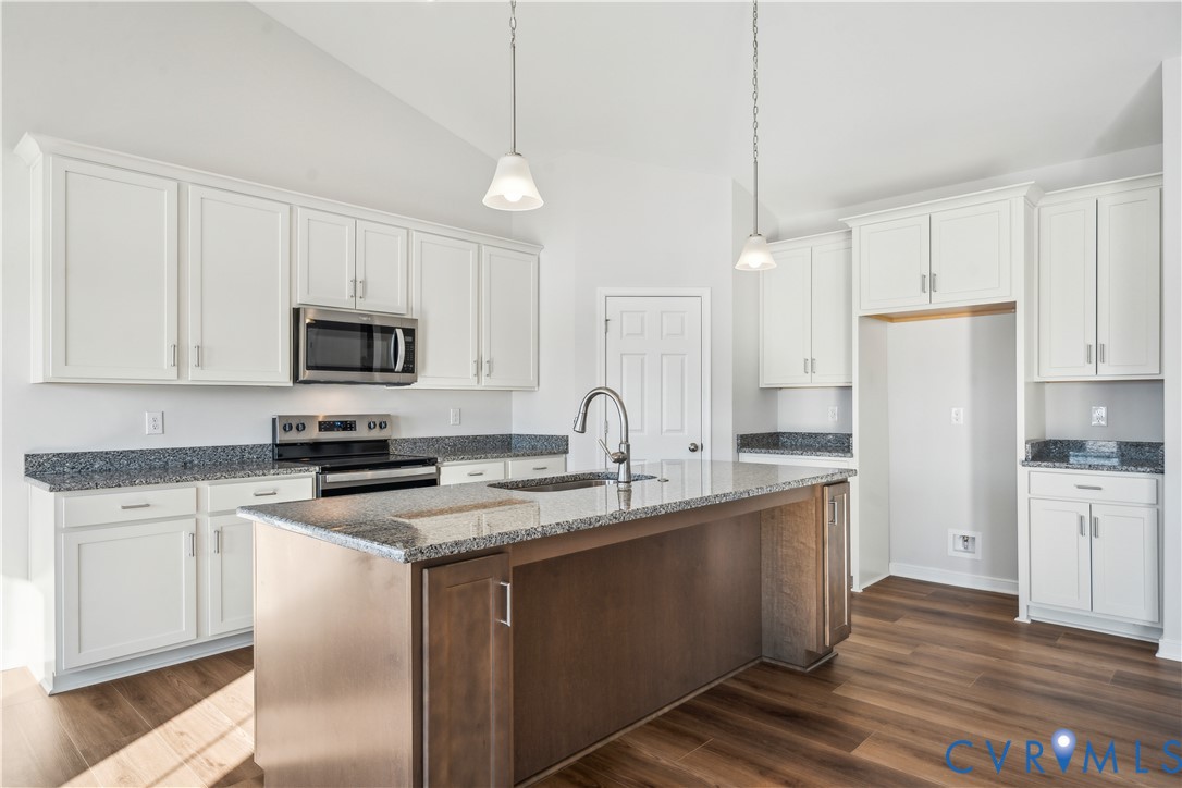 115 Logan Way Tappahannock, VA 22560 - Photo 8 of 29 a kitchen with stainless steel appliances granite countertop a stove a sink dishwasher a refrigerator and white cabinets with wooden floor