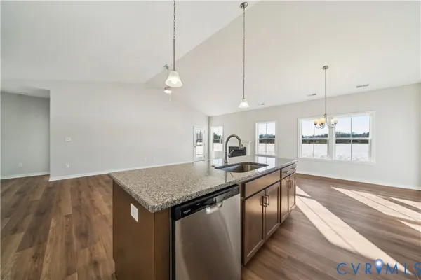 a kitchen with stainless steel appliances granite countertop a sink a stove and a wooden floors