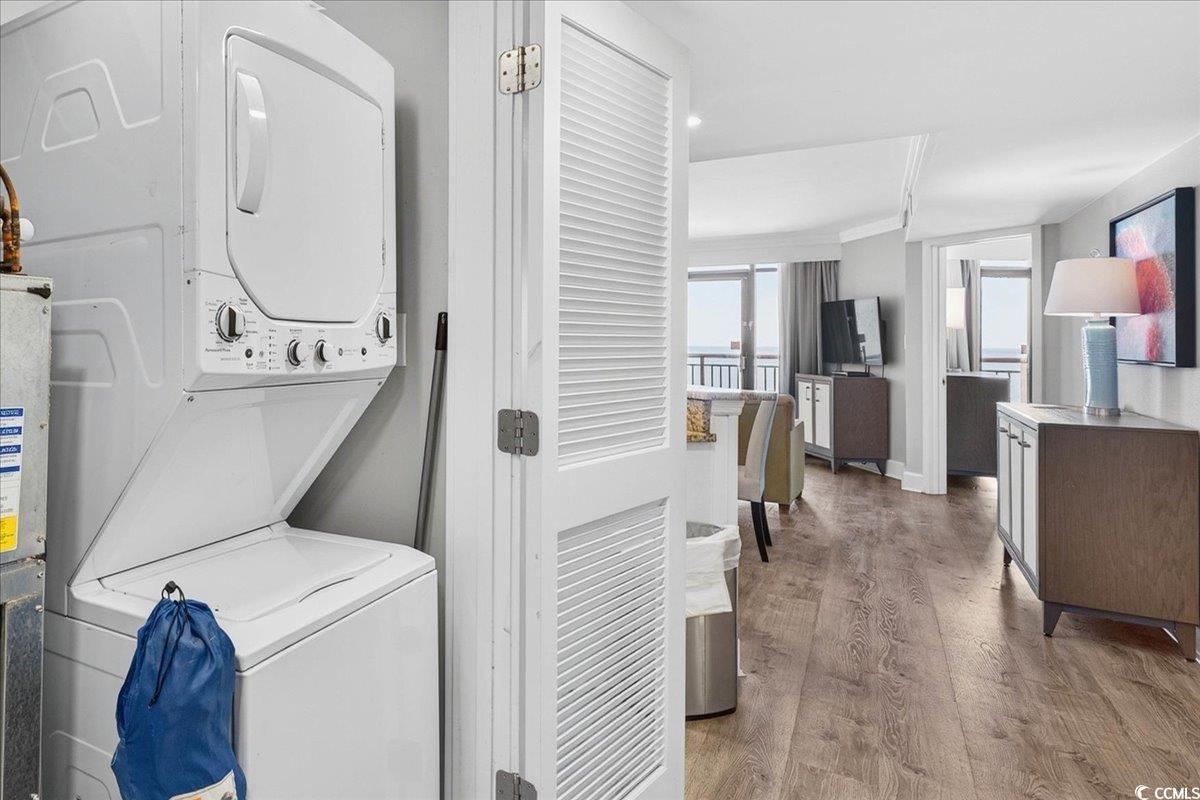 7200 North Ocean Boulevard, Unit 1155 Myrtle Beach, SC 29572 - Photo 25 of 40 Laundry room featuring stacked washer / dryer, wood finished floors, and water heater