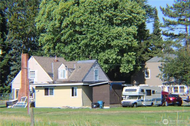 a front view of a house with a garden and trees