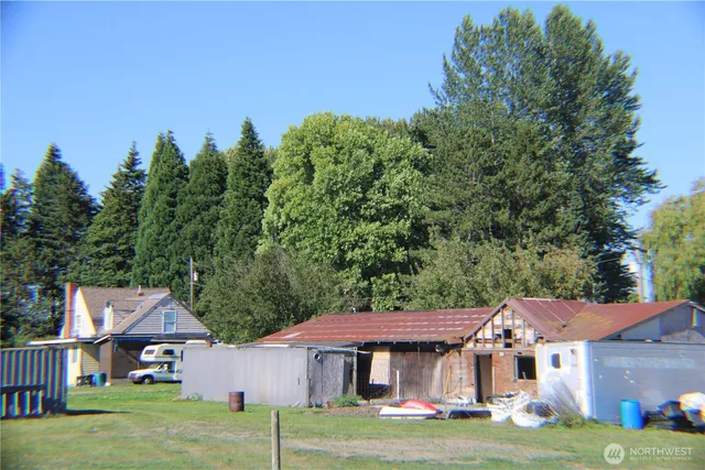 a aerial view of a house next to a big yard with large trees