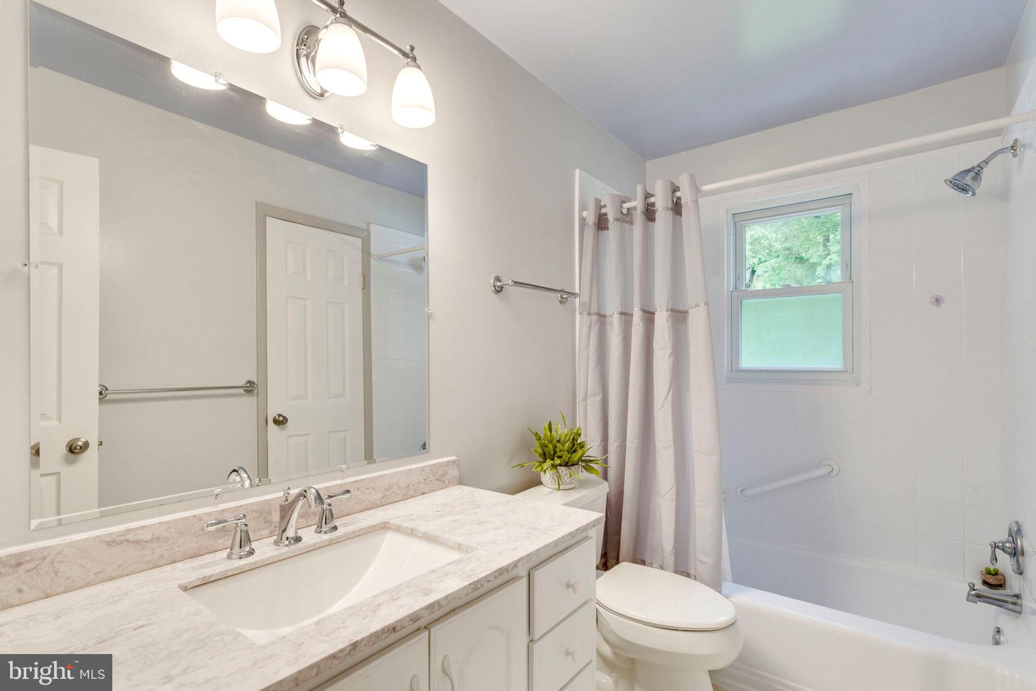 6016 Craft Road Alexandria, VA 22310 - Photo 14 of 32 a bathroom with a granite countertop sink a toilet a mirror a vanity and shower