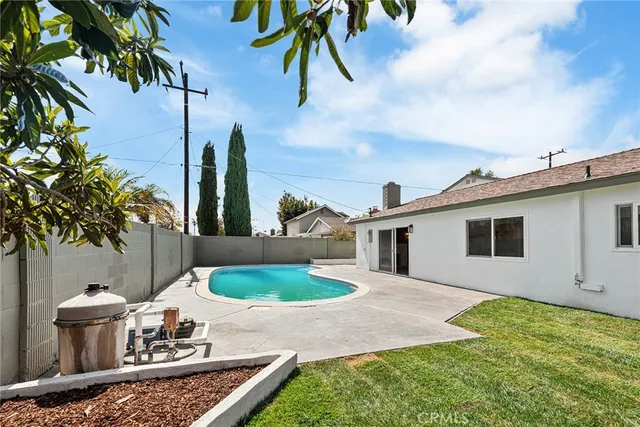 a view of backyard with barbeque grill and seating space