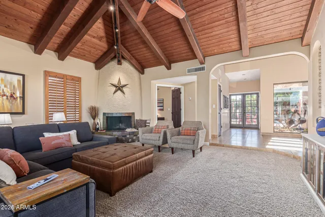 a spacious bedroom with a bed a couch and a flat tv screen